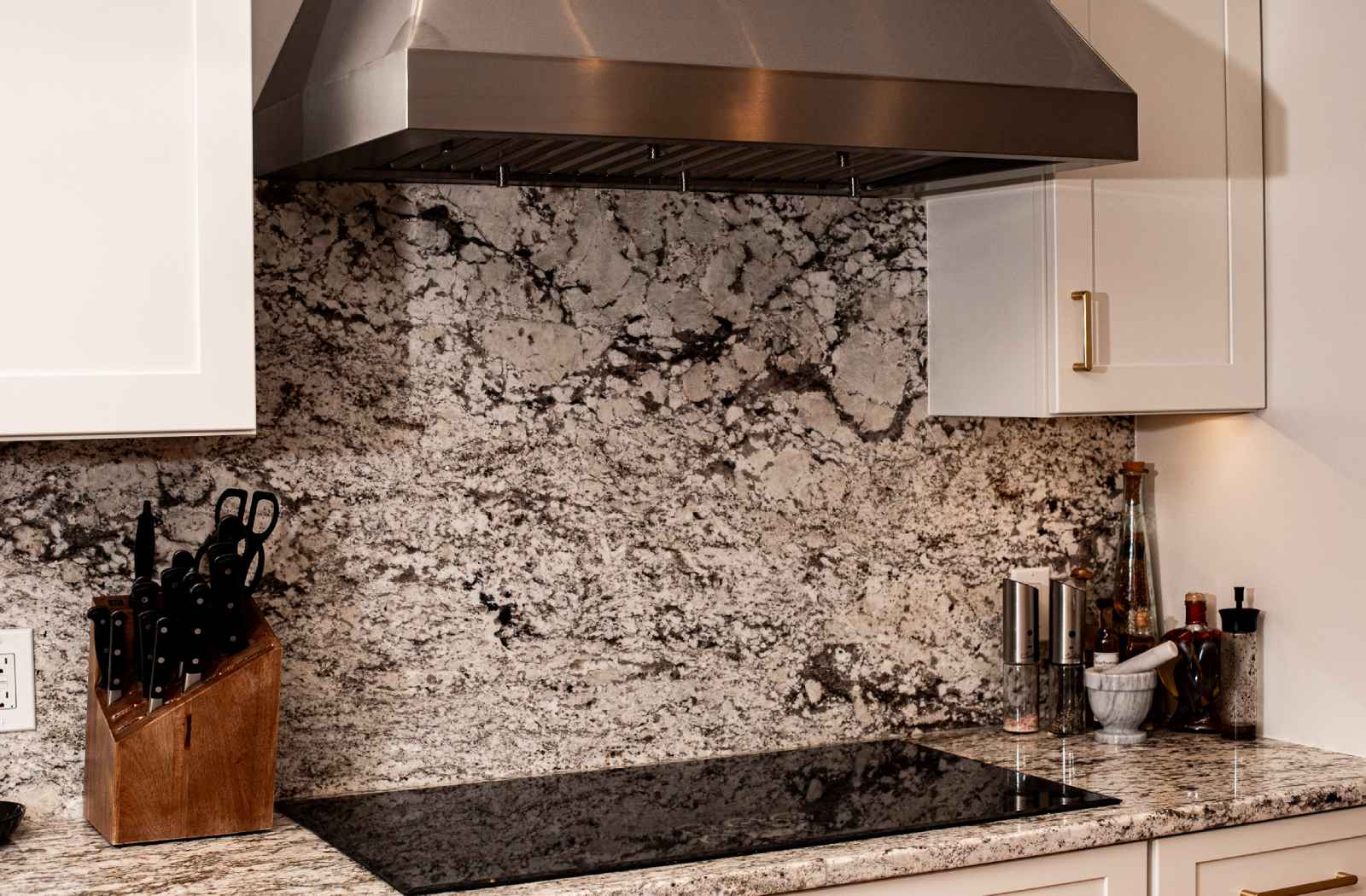 Cooking area with custom granite countertops & backsplash.