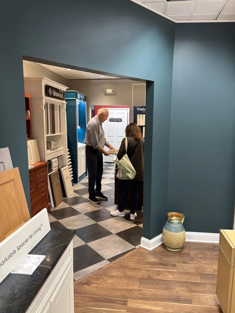 designer-assisting-customer A Connecticut renovation contractor assists a homeowner with choosing materials at a kitchen design showroom during the kitchen remodel planning phase.