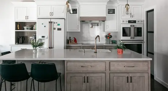 Kitchen sink area showing how a continuous white countersplash creates an uninterrupted, full-height backsplash design.