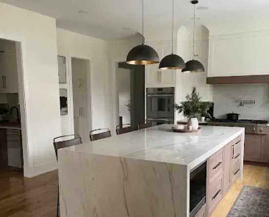 Professional installation of countersplash backsplash with large stone slab being fitted on kitchen wall with precise measurements and cutouts