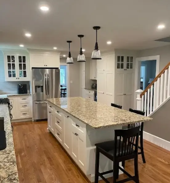 Modern kitchen featuring white lower cabinets and a thick marble island, highlighting material choices that provide a seamless kitchen design.