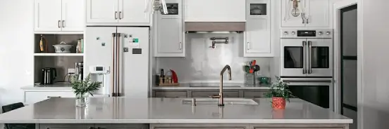 kitchen-heart-of-home-family-gathering Renovated white kitchen with stainless backsplash, French-door wall oven, and an oversized island built for family gatherings.