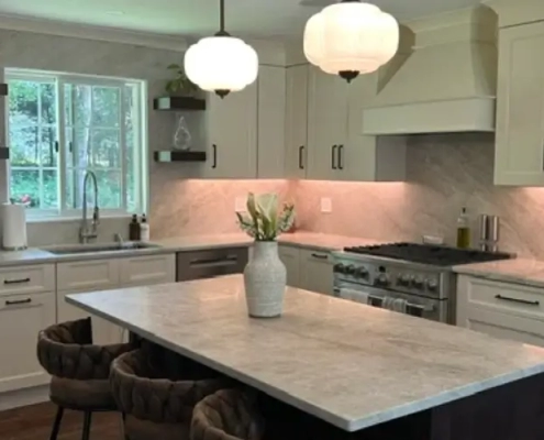 Bright Connecticut kitchen upgrade featuring a pendant-lit marble island, pro-style range, and warm under-cabinet task lighting.