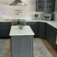 U-shaped kitchen with charcoal shaker cabinets, glass-front uppers, white marble-look counters, and a small island, showing custom cabinets in CT.
