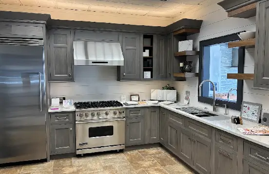 custom-kitchen-remodel-transformation Gray custom kitchen cabinets with crown molding frame a pro-style range and stainless hood, showing the upgrade custom cabinetry brings to a remodel.